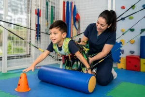 Criança em sessão de fisioterapia motora intensiva com vestimenta terapêutica